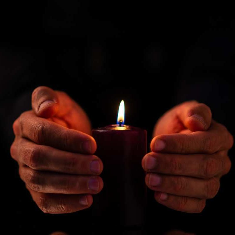 man-covering-burning-candle man-covering-burning-candle
